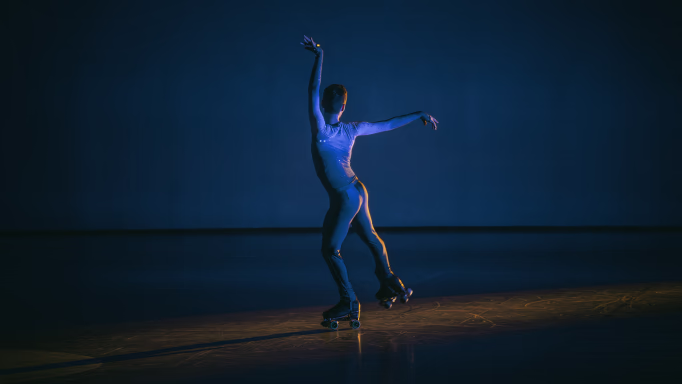 Photograph of an artistic skater under stage lights.