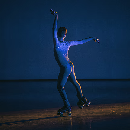 Photograph of an artistic skater under stage lights.